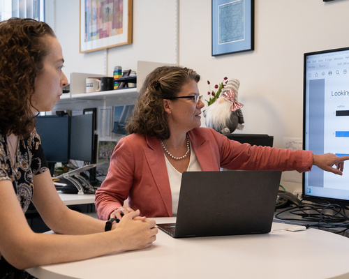 Two scientists look at a computer screen in an office.