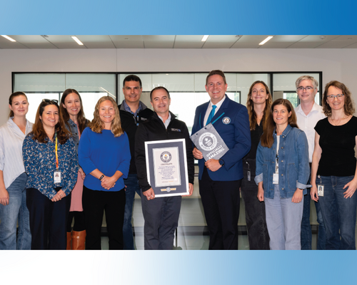 Group of people pose for photo, with one holding certificate