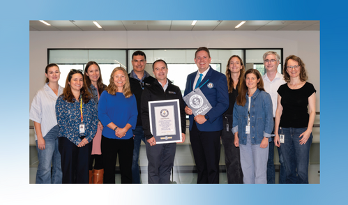 Group of people pose for photo, with one holding certificate
