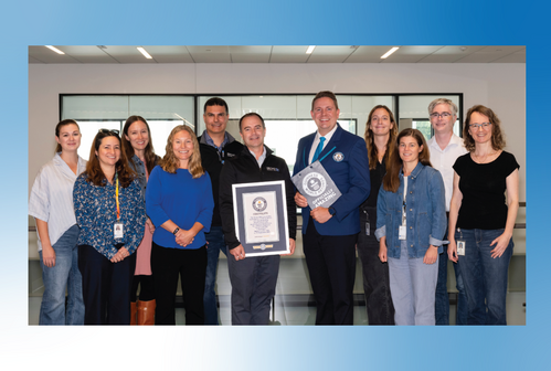 Group of people pose for photo, with one holding certificate
